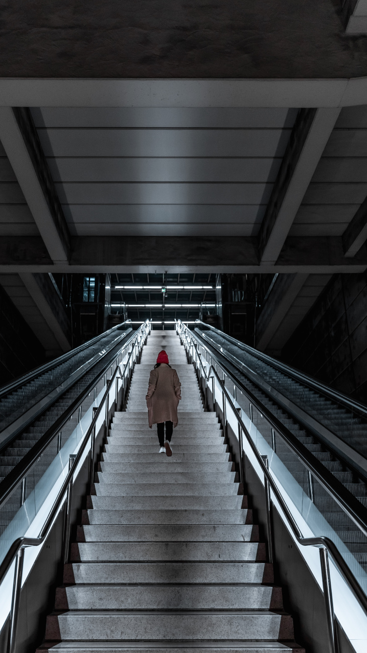 Person Walking on Gray and Black Escalator. Wallpaper in 750x1334 Resolution