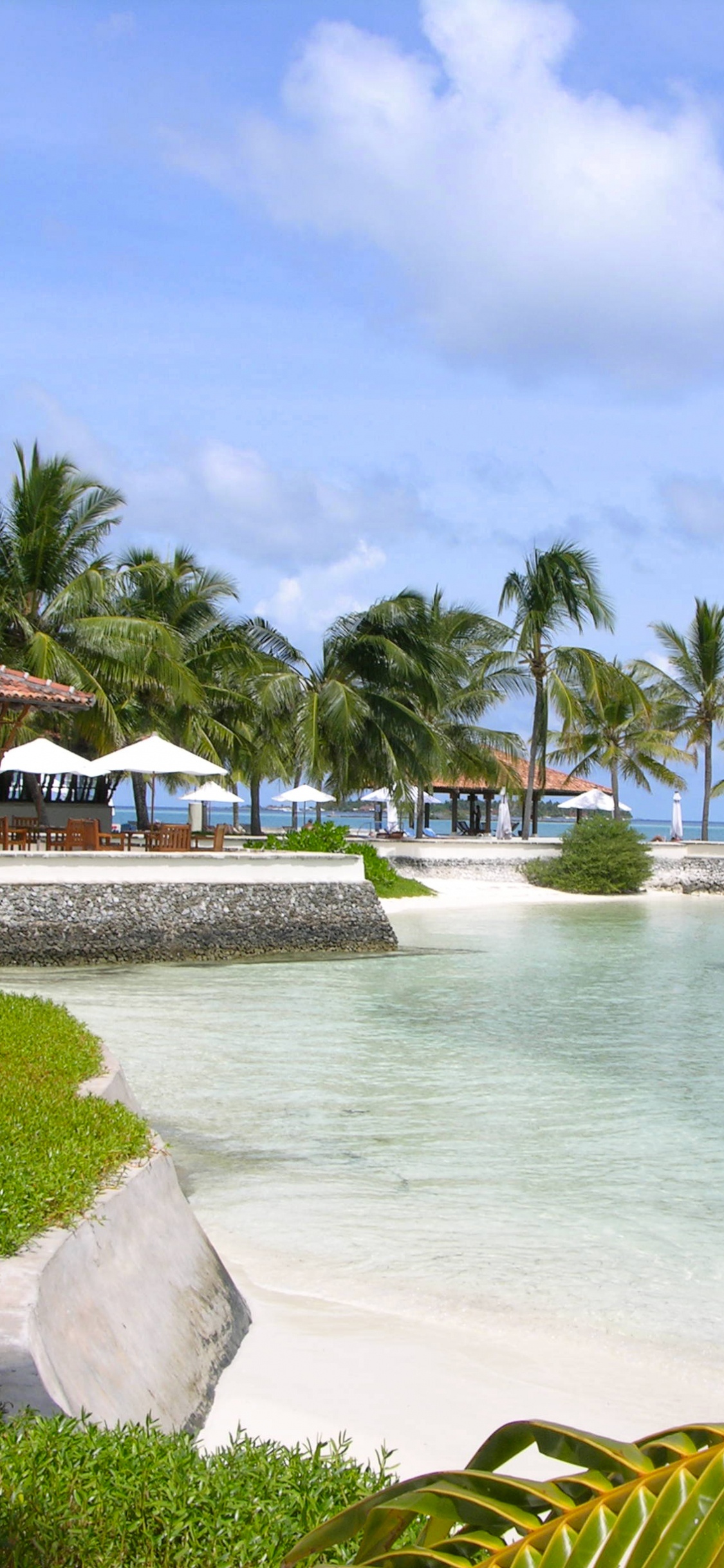 White and Brown Wooden House Near Body of Water During Daytime. Wallpaper in 1125x2436 Resolution