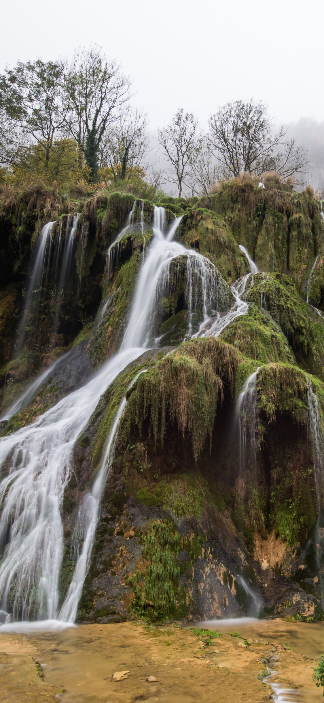 Wasserfälle Auf Braunem Felsigem Berg Tagsüber. Wallpaper in 1125x2436 Resolution