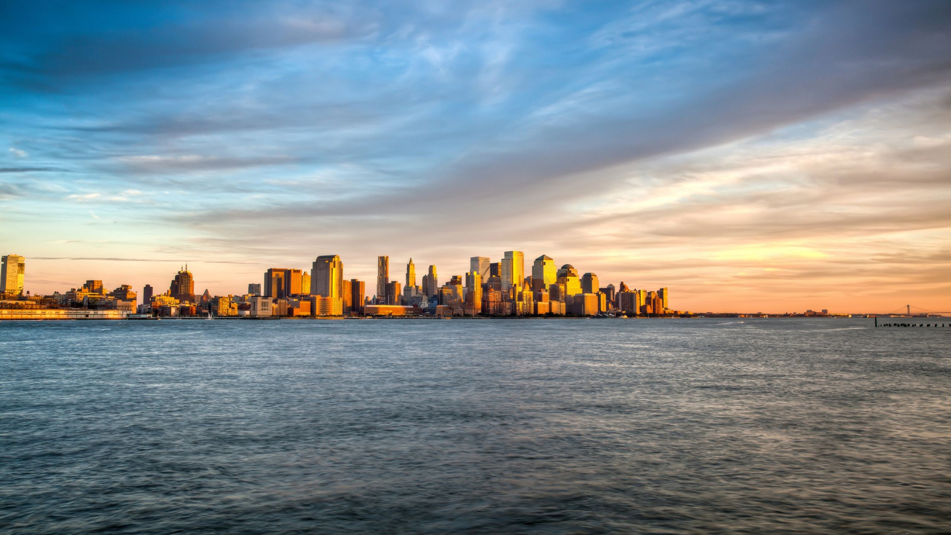 City Skyline Across Body of Water During Sunset. Wallpaper in 1920x1080 Resolution