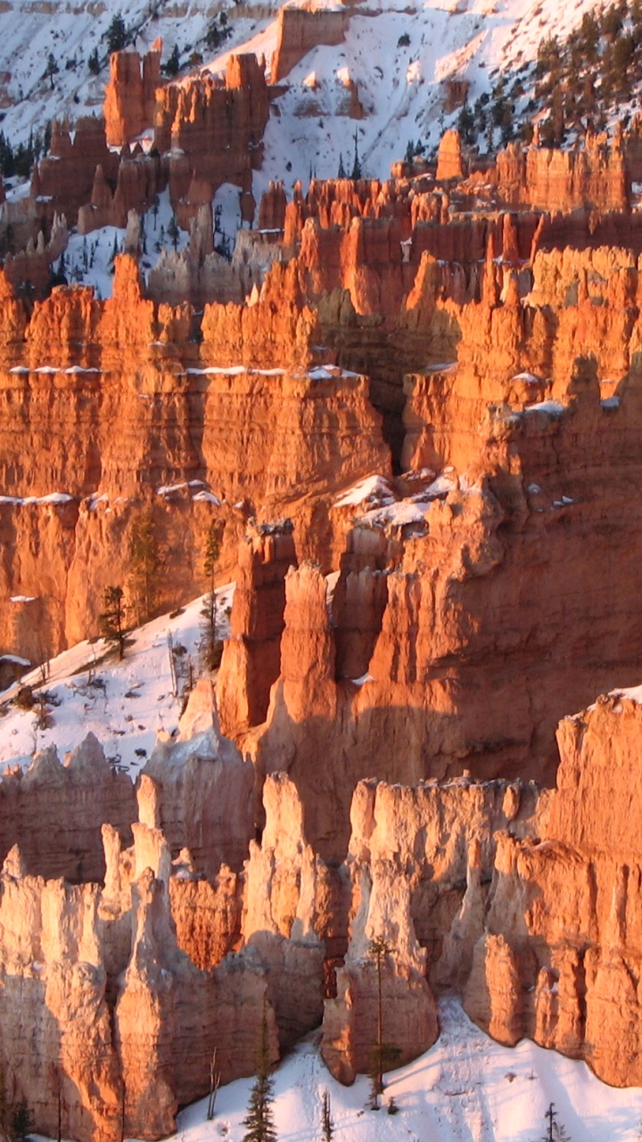Brown Rocky Mountain Covered With Snow During Daytime. Wallpaper in 720x1280 Resolution