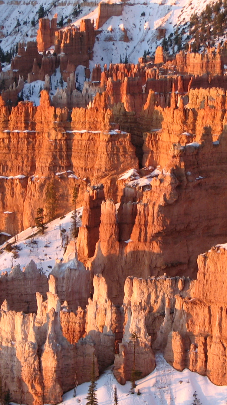 Brown Rocky Mountain Covered With Snow During Daytime. Wallpaper in 750x1334 Resolution