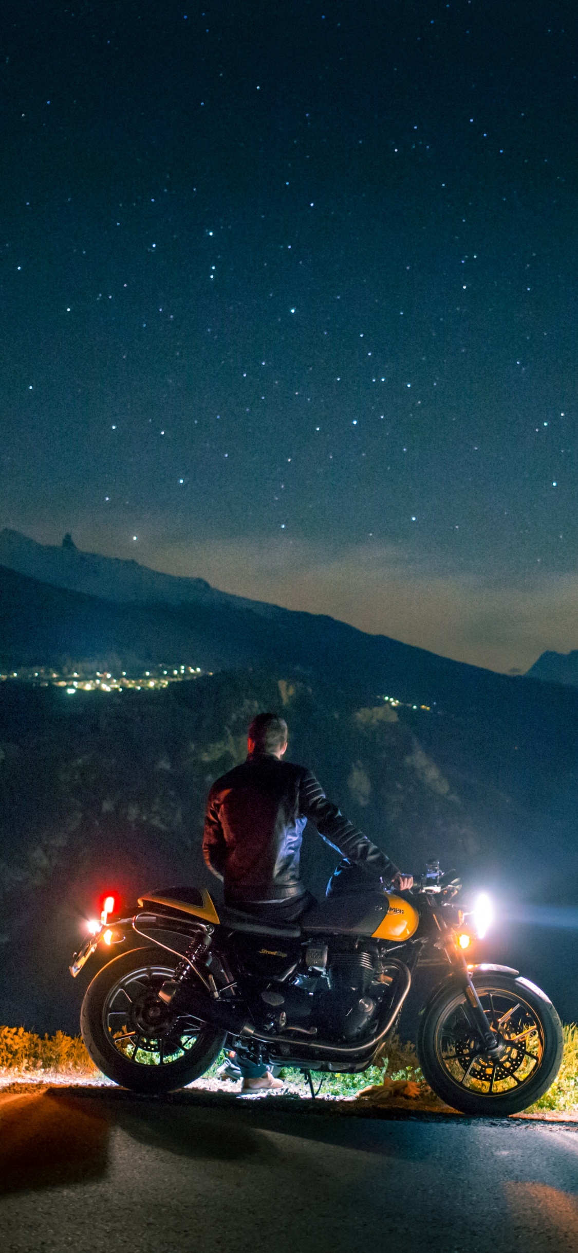 Homme Monté Sur Moto Sur Route Pendant la Nuit. Wallpaper in 1125x2436 Resolution