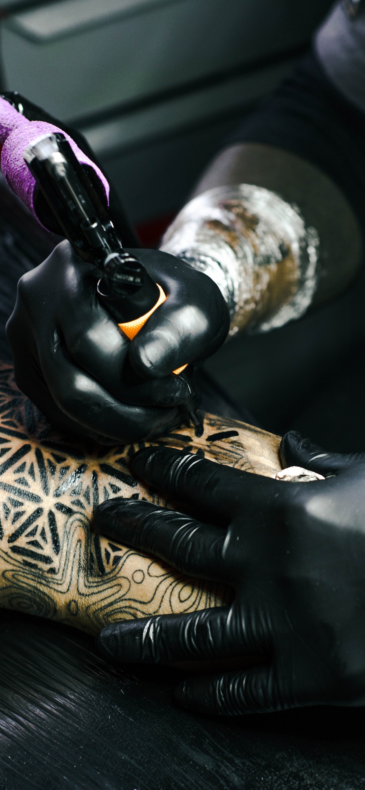 Person in Black Leather Gloves Holding Black and Gold Hand Tool. Wallpaper in 1242x2688 Resolution