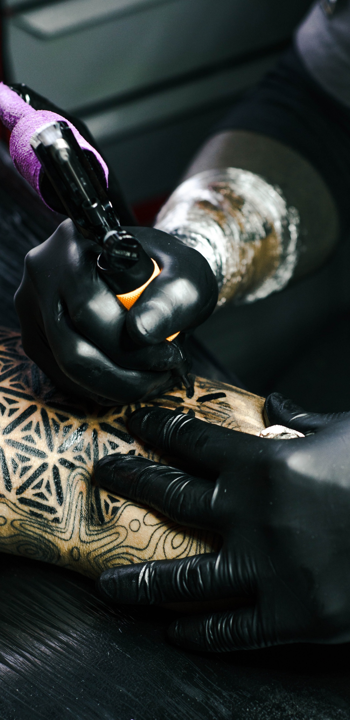 Person in Black Leather Gloves Holding Black and Gold Hand Tool. Wallpaper in 1440x2960 Resolution