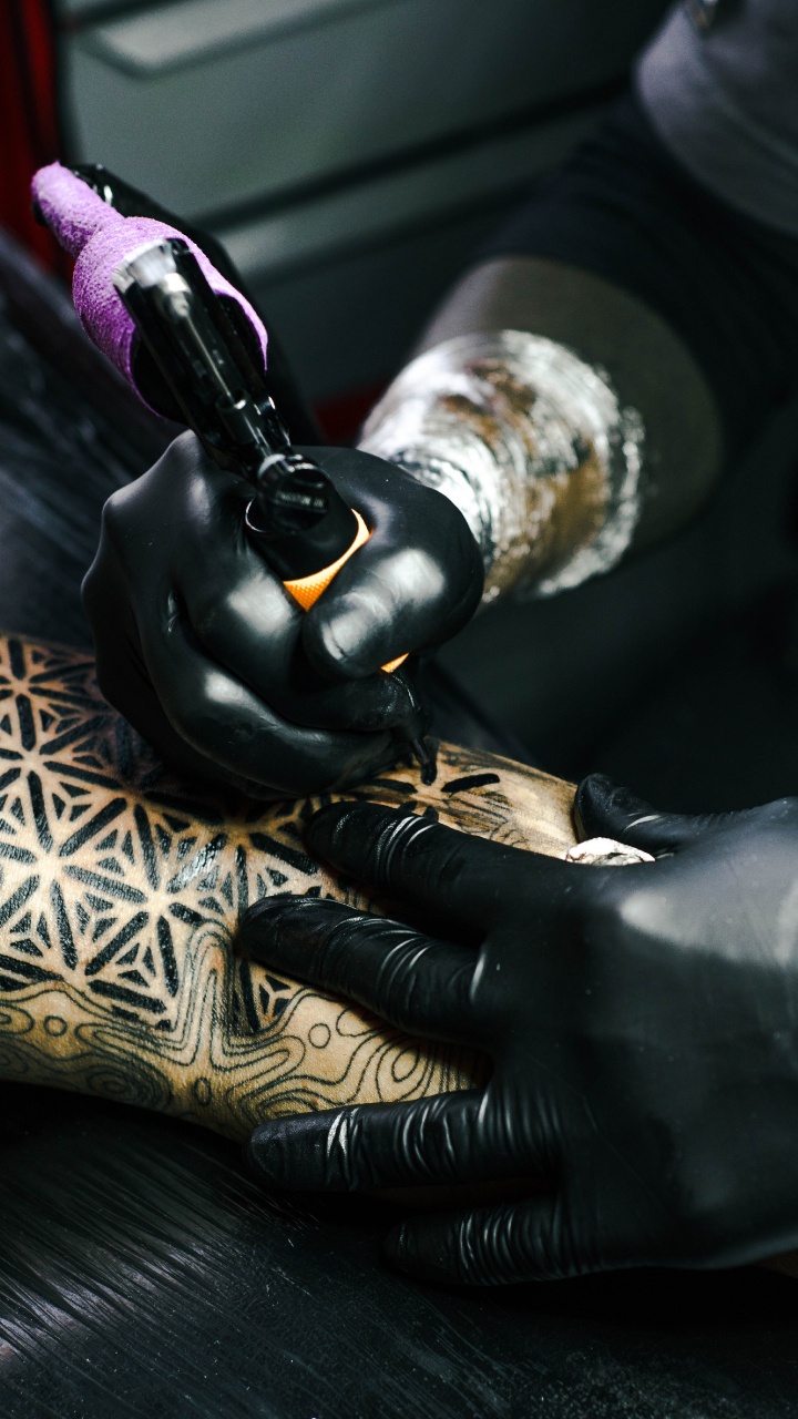 Person in Black Leather Gloves Holding Black and Gold Hand Tool. Wallpaper in 720x1280 Resolution