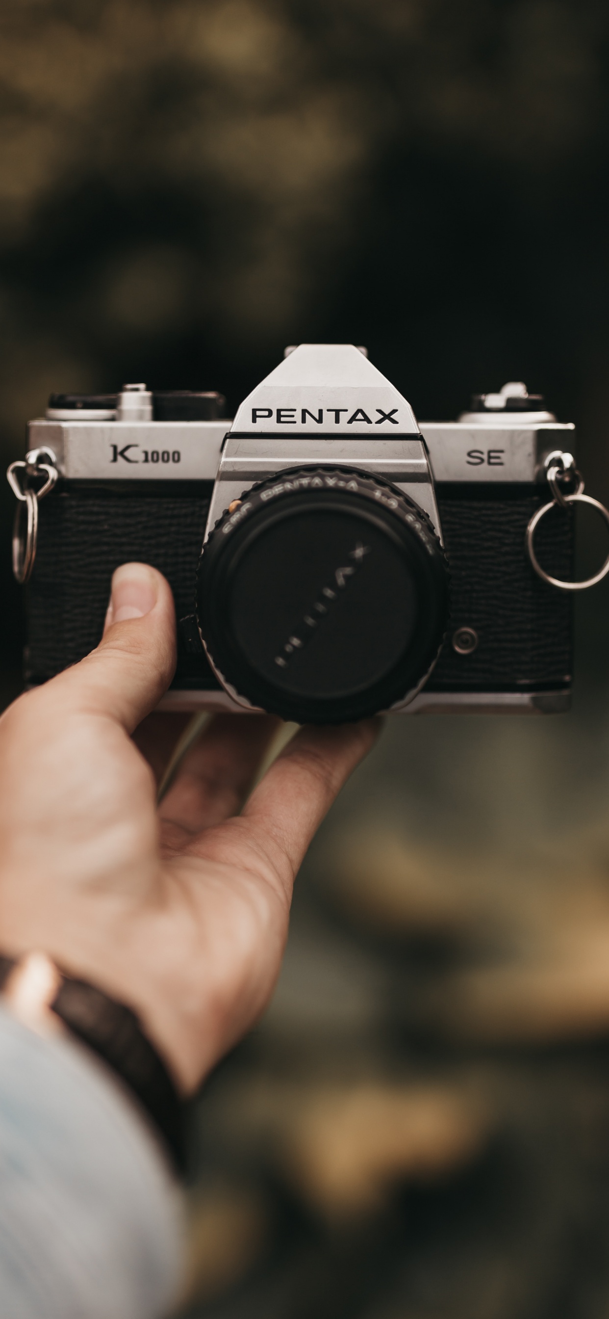 Personne Tenant un Appareil Photo Reflex Numérique Nikon Noir et Argent. Wallpaper in 1242x2688 Resolution