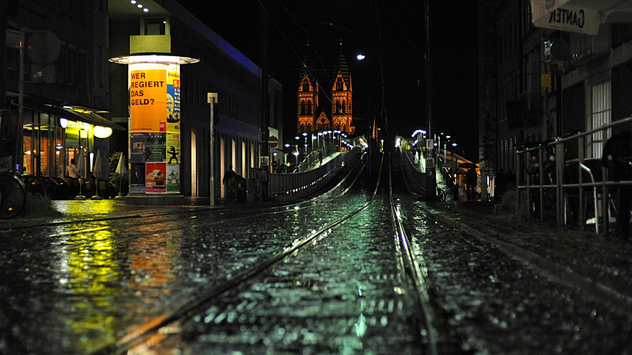 Train Rail Near City Buildings During Night Time. Wallpaper in 1280x720 Resolution