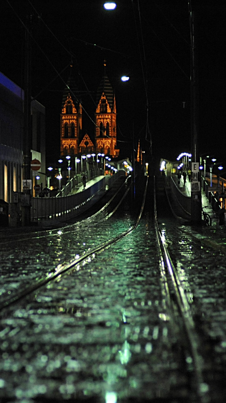 Rail de Train Près Des Bâtiments de la Ville Pendant la Nuit. Wallpaper in 750x1334 Resolution