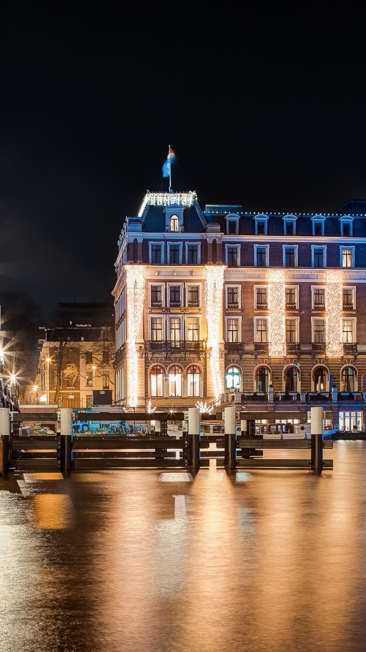Edificio de Hormigón Blanco Cerca Del Cuerpo de Agua Durante la Noche. Wallpaper in 720x1280 Resolution