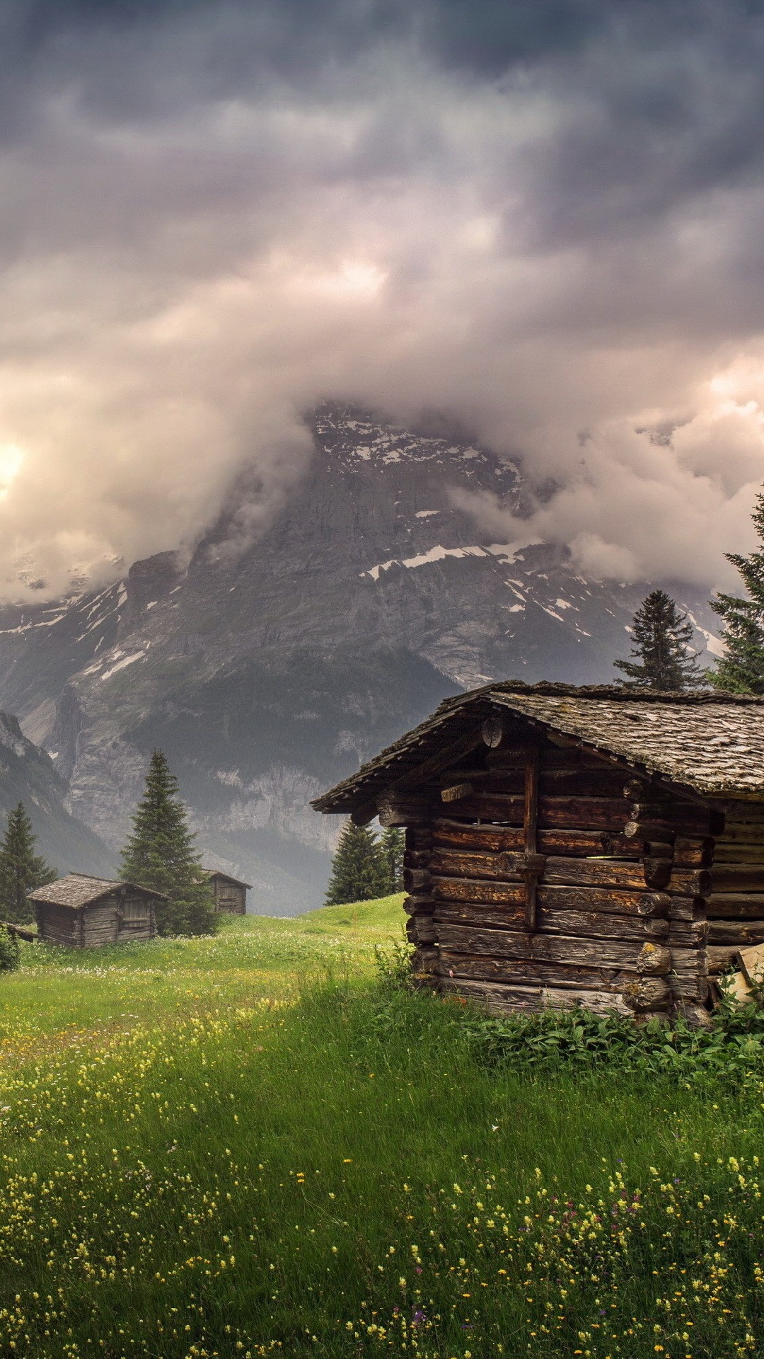 Braunes Holzhaus Auf Grünem Grasfeld in Der Nähe Des Berges Unter Weißen Wolken Tagsüber. Wallpaper in 1080x1920 Resolution