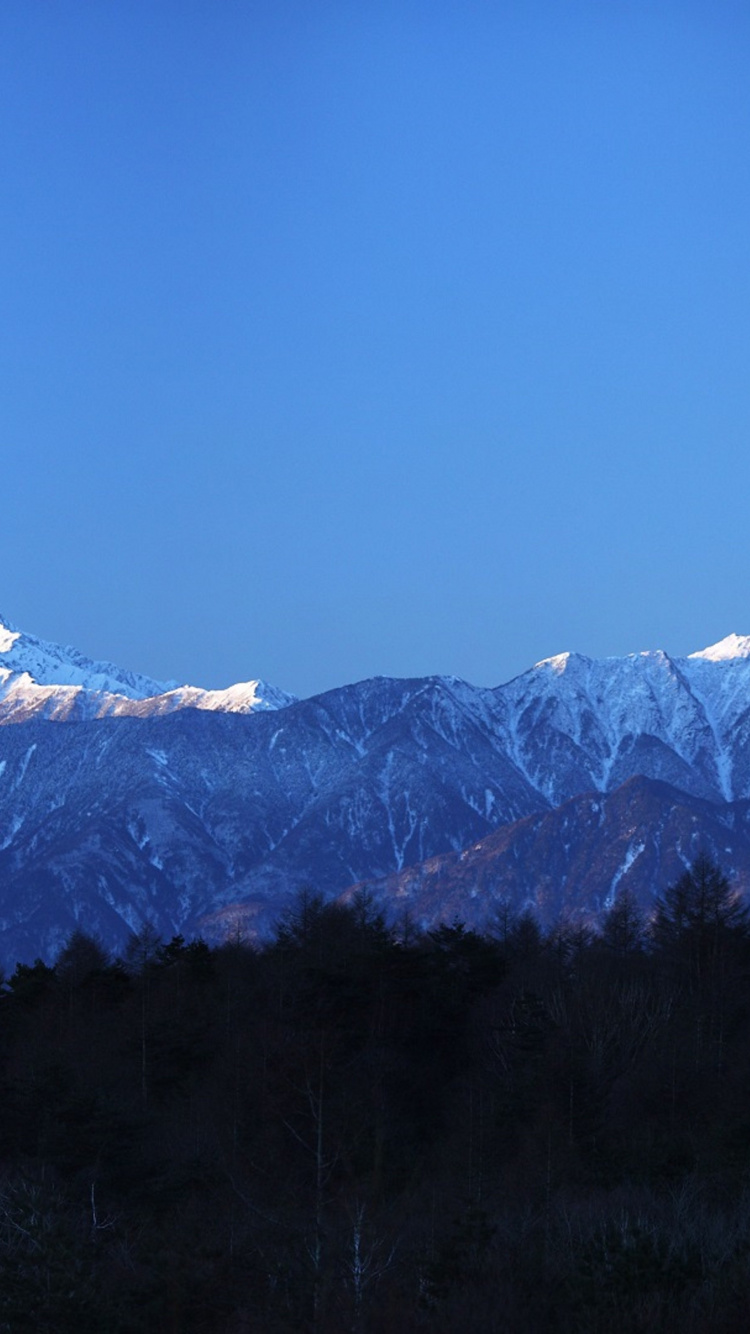Montaña Cubierta de Nieve Bajo un Cielo Azul Durante el Día. Wallpaper in 750x1334 Resolution