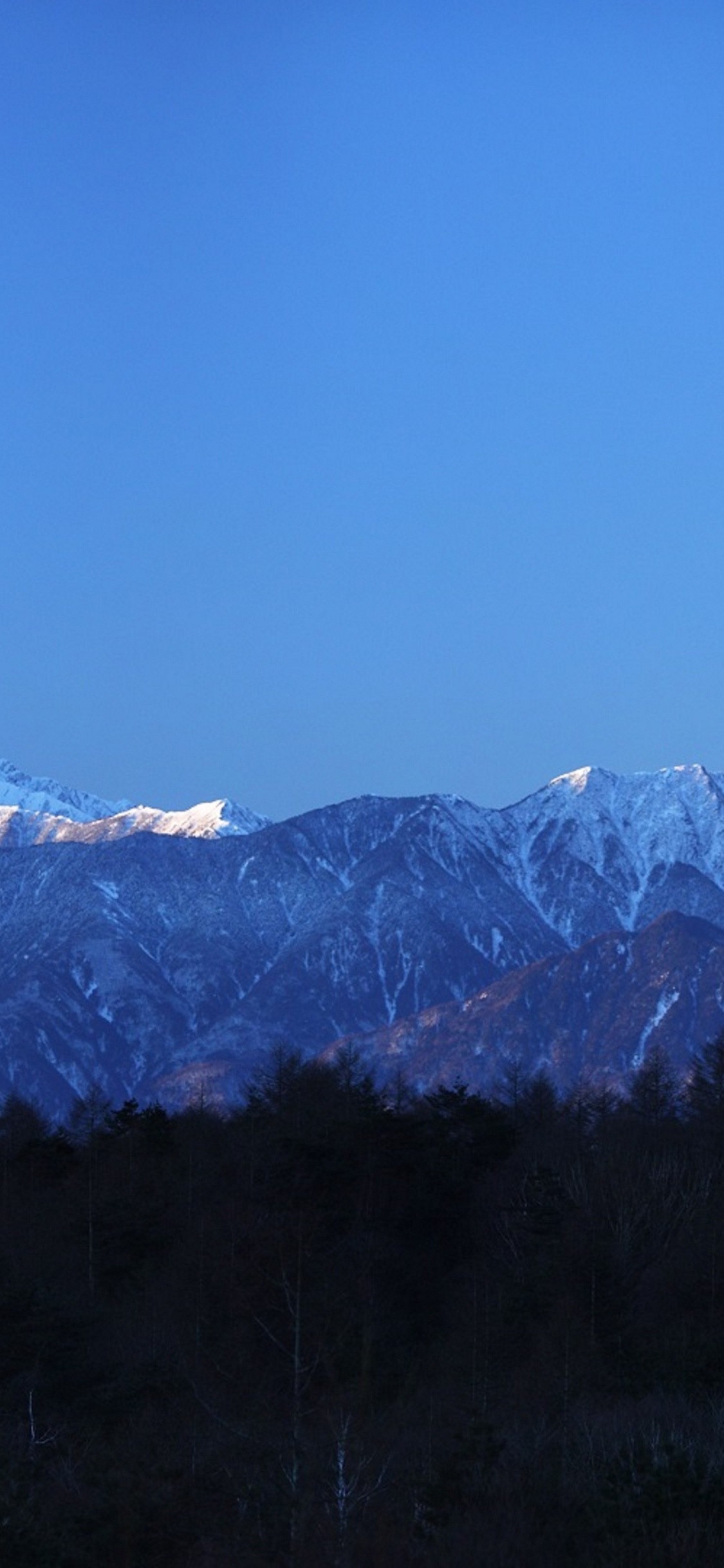 Snow Covered Mountain Under Blue Sky During Daytime. Wallpaper in 1125x2436 Resolution