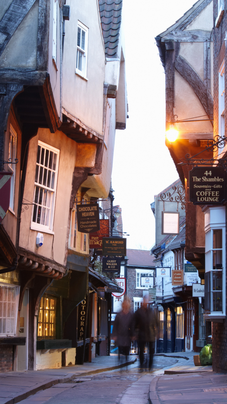 People Walking on Street Between Buildings During Daytime. Wallpaper in 750x1334 Resolution