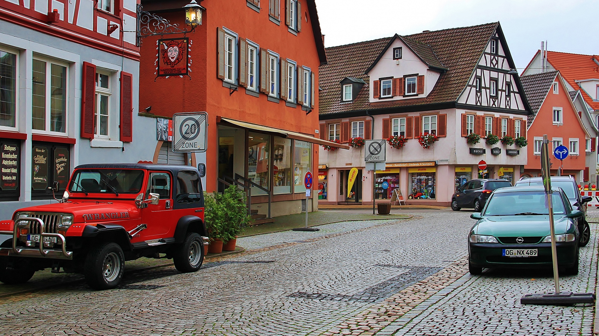 Roter Und Schwarzer Geländewagen, Der Tagsüber Neben Dem Roten Und Weißen Betongebäude Geparkt Ist. Wallpaper in 1920x1080 Resolution