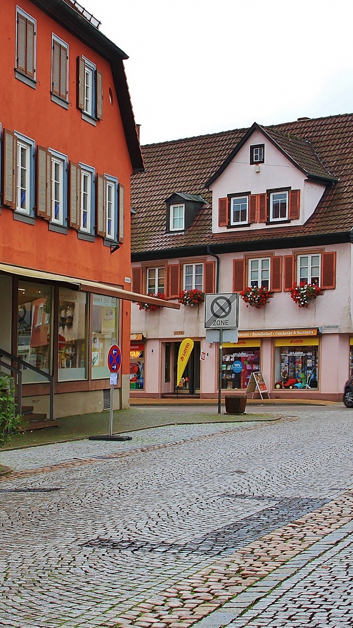 Roter Und Schwarzer Geländewagen, Der Tagsüber Neben Dem Roten Und Weißen Betongebäude Geparkt Ist. Wallpaper in 720x1280 Resolution