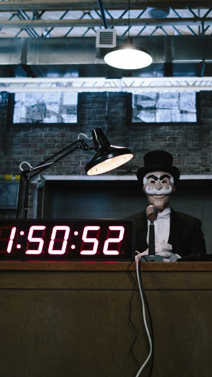 Mann Mit Schwarzem Hut, Der Neben Einem Braunen Holzschreibtisch Steht. Wallpaper in 720x1280 Resolution