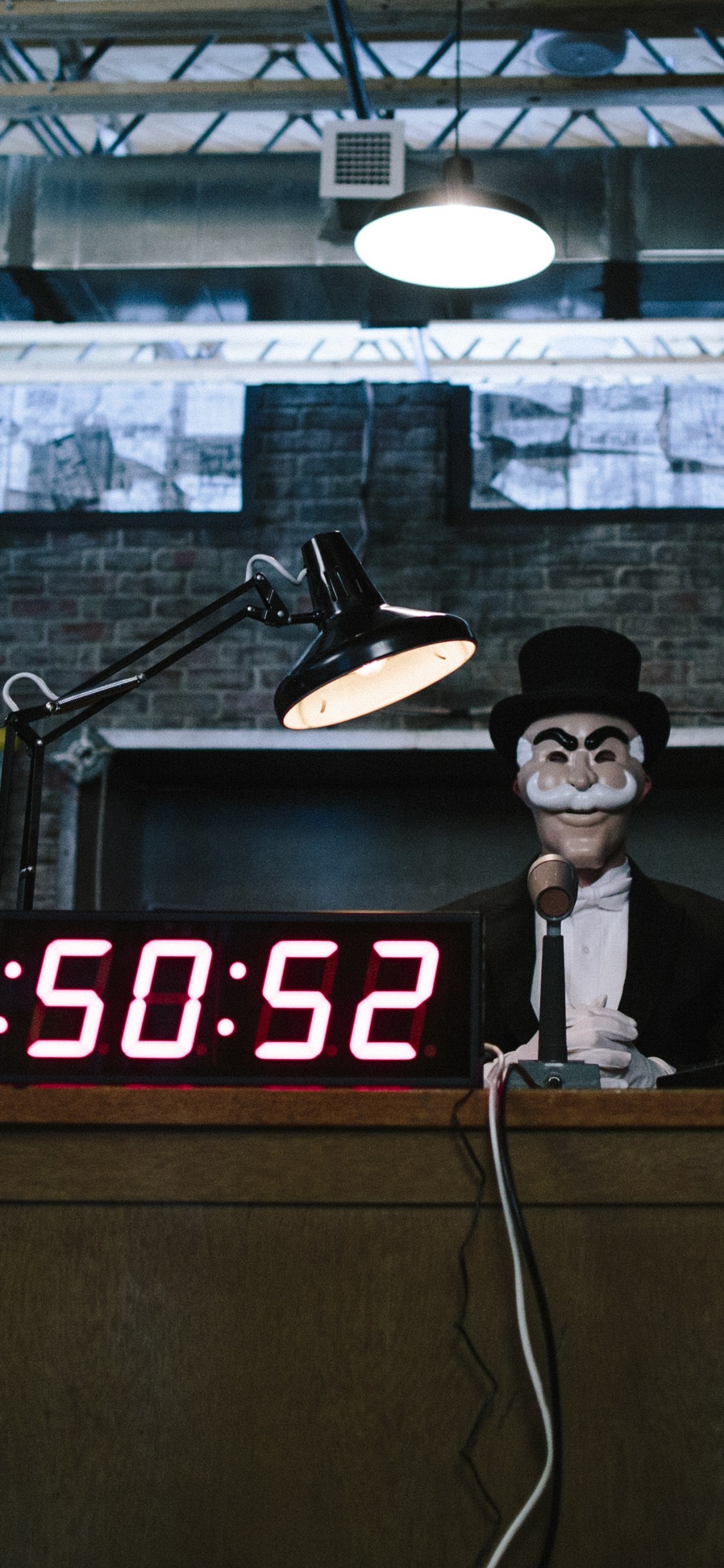 Man in Black Hat Standing Near Brown Wooden Desk. Wallpaper in 1125x2436 Resolution