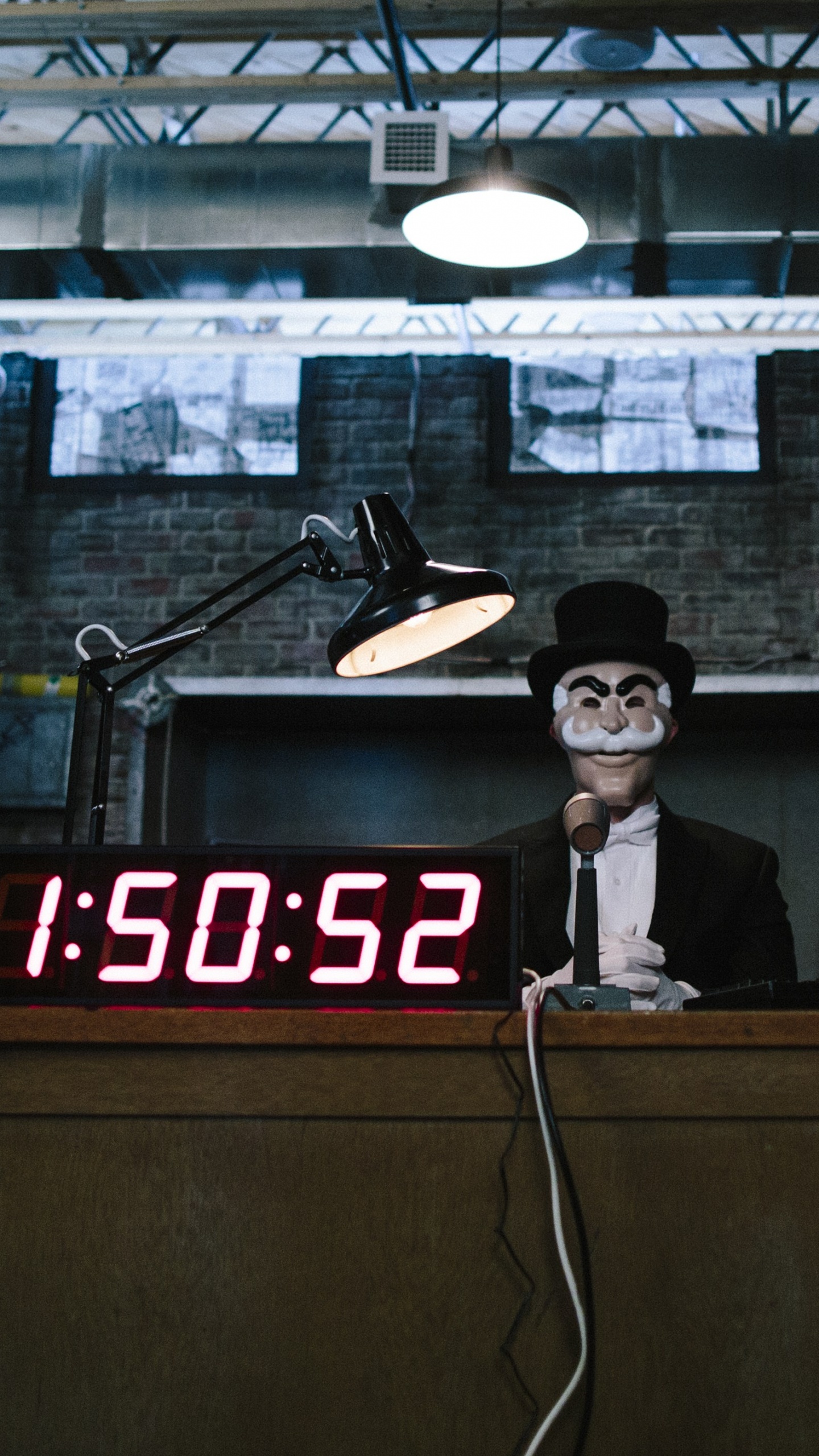 Man in Black Hat Standing Near Brown Wooden Desk. Wallpaper in 1440x2560 Resolution