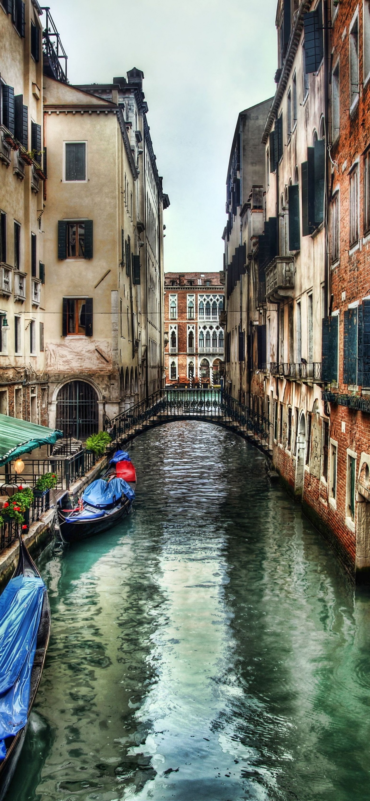 Blue Boat on River Between Brown Concrete Buildings During Daytime. Wallpaper in 1242x2688 Resolution