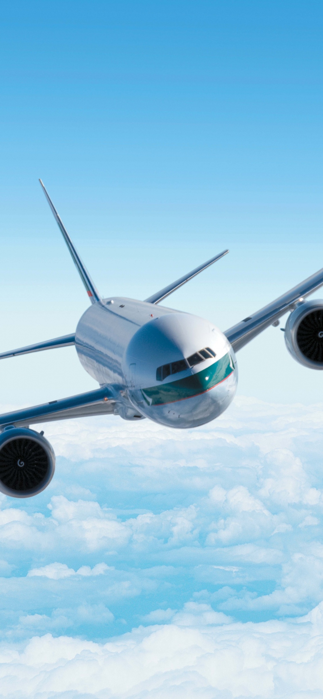 Avión Blanco en el Aire Bajo un Cielo Azul Durante el Día. Wallpaper in 1125x2436 Resolution