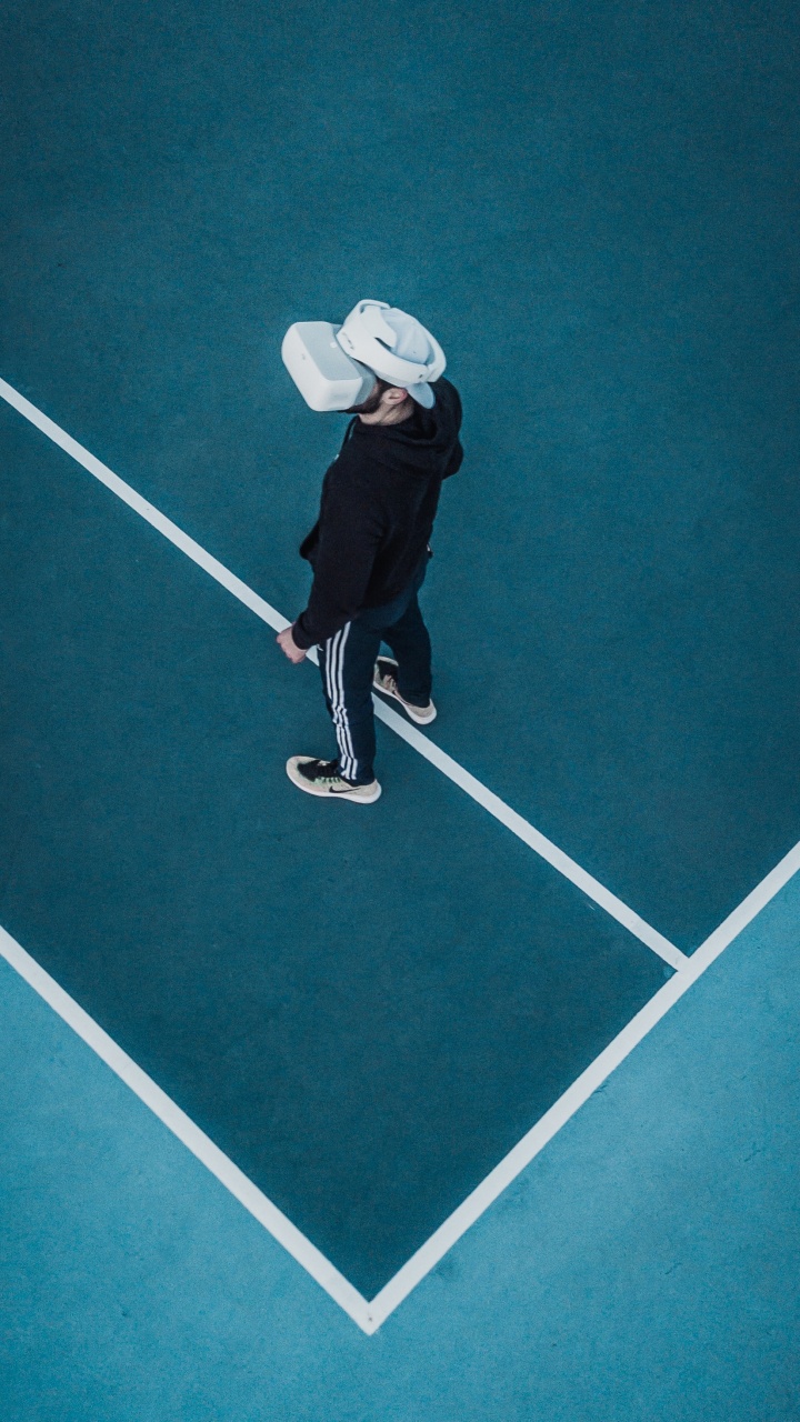 Person in Black Jacket and White Hat Playing on Green Floor. Wallpaper in 720x1280 Resolution