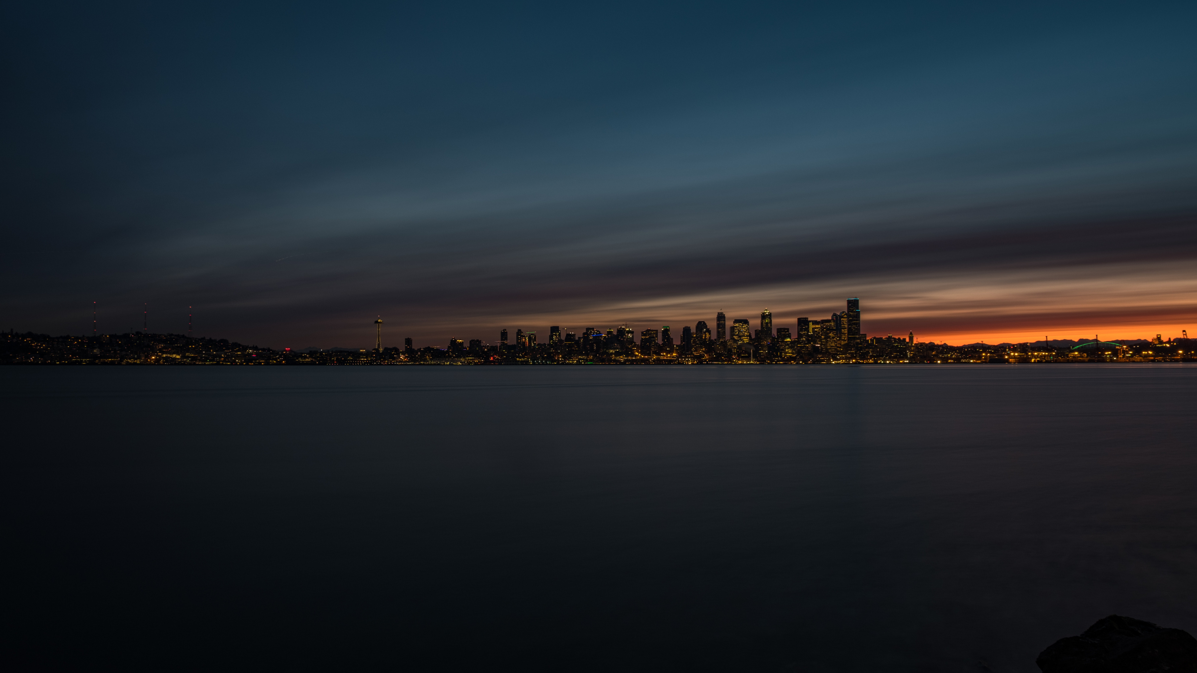 Skyline Der Stadt Über Gewässer Während Der Nacht. Wallpaper in 3840x2160 Resolution