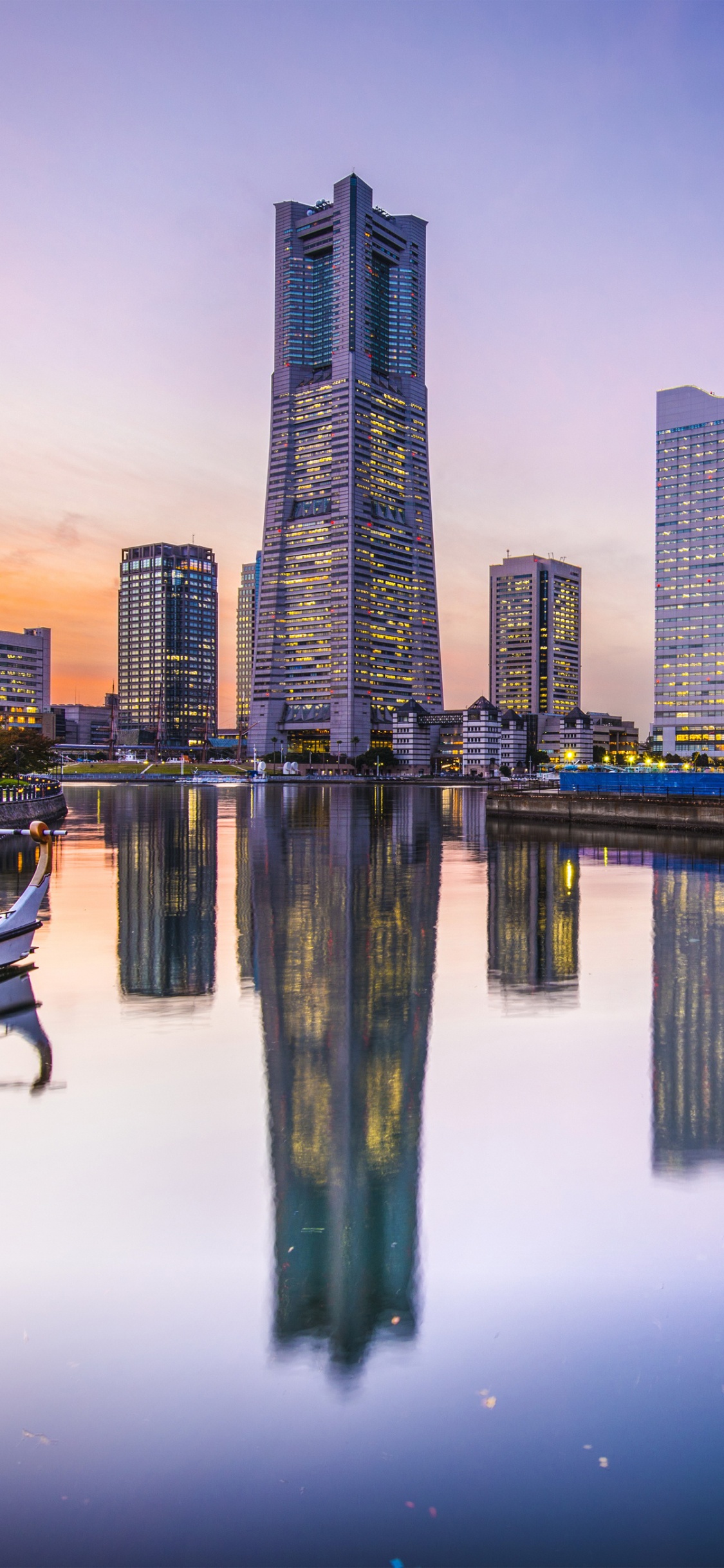 City Skyline Across Body of Water During Night Time. Wallpaper in 1125x2436 Resolution