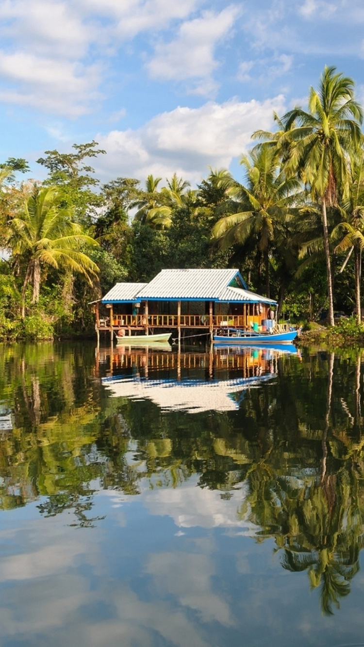 Maison en Bois Bleu et Blanc Sur le Lac Pendant la Journée. Wallpaper in 750x1334 Resolution