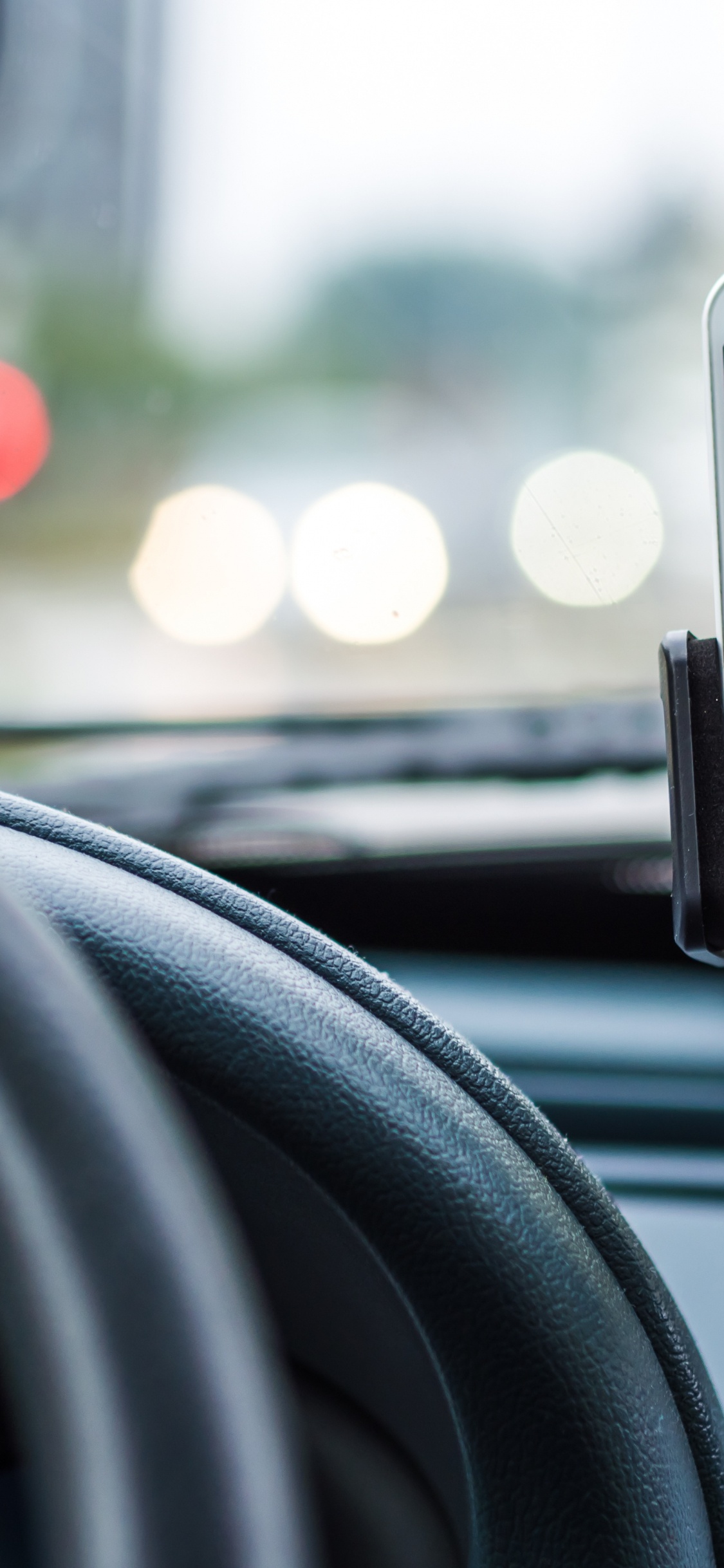 Silver Iphone 6 on Car Steering Wheel. Wallpaper in 1125x2436 Resolution