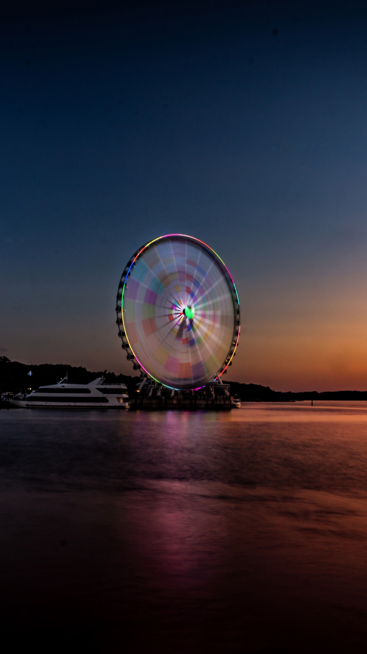 Ferris Wheel Near Body of Water During Night Time. Wallpaper in 750x1334 Resolution
