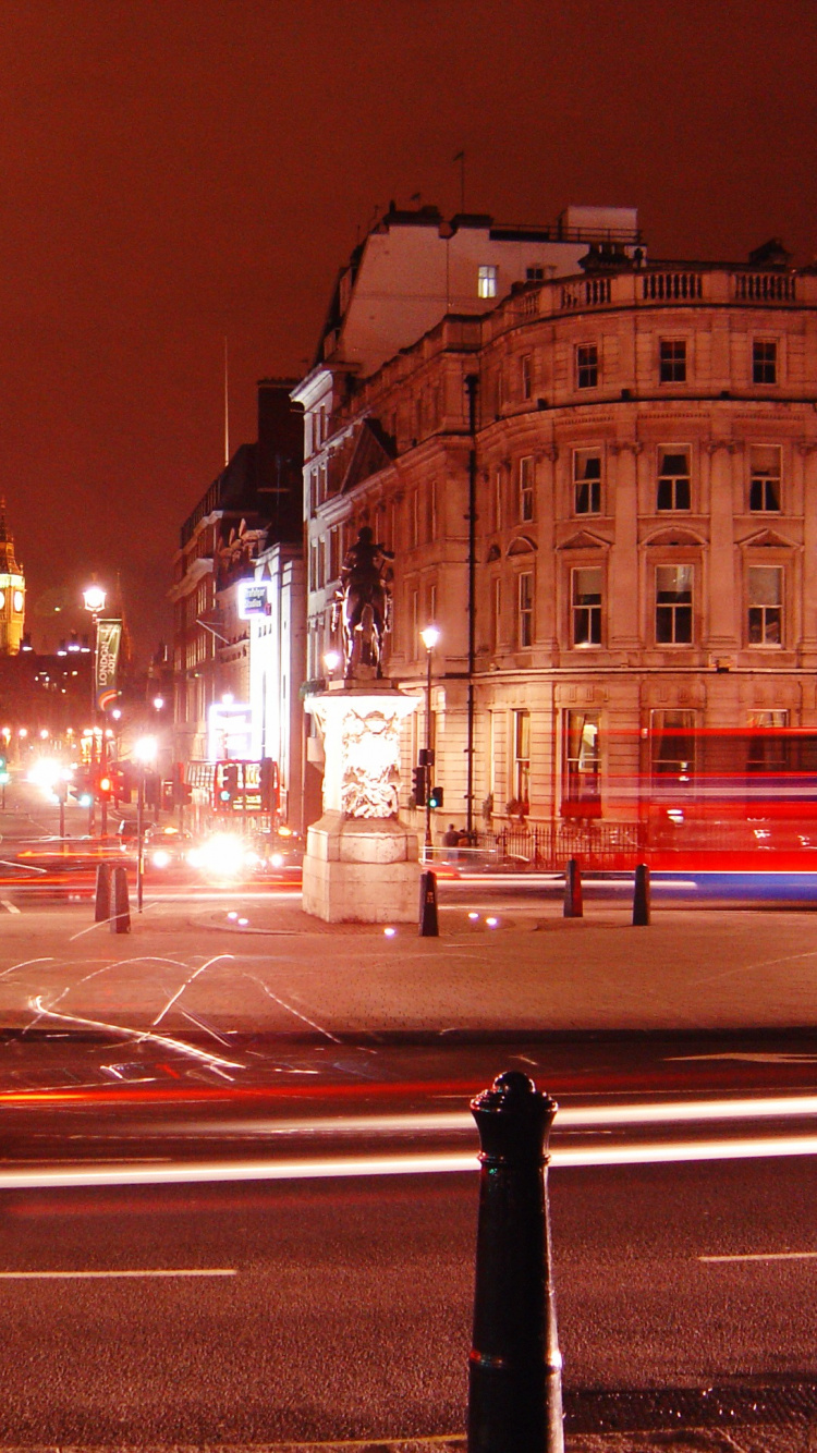 Person in Black Coat Standing on Road During Night Time. Wallpaper in 750x1334 Resolution