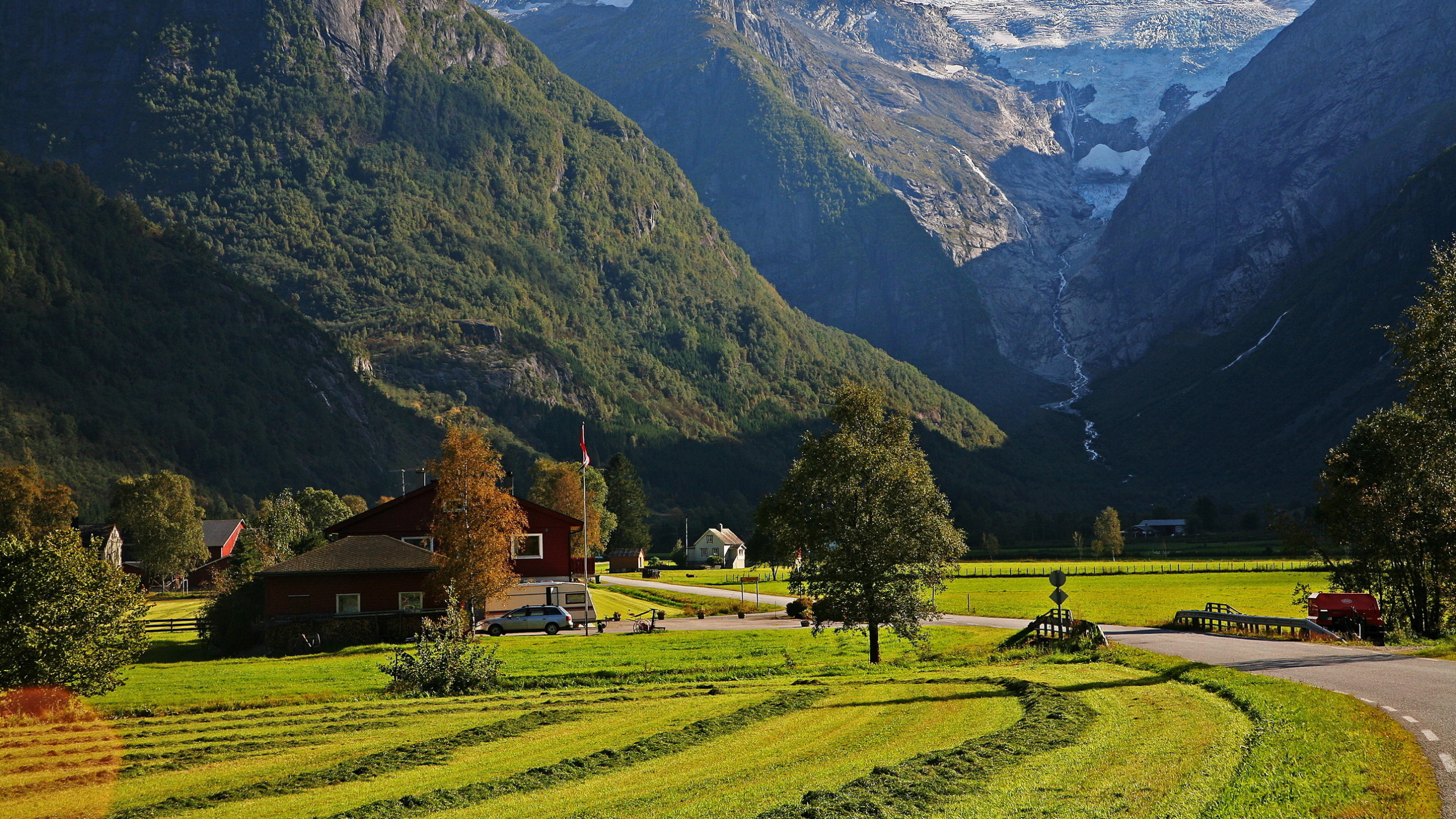 Braunes Haus Auf Grünem Grasfeld in Der Nähe Des Berges Tagsüber. Wallpaper in 2560x1440 Resolution