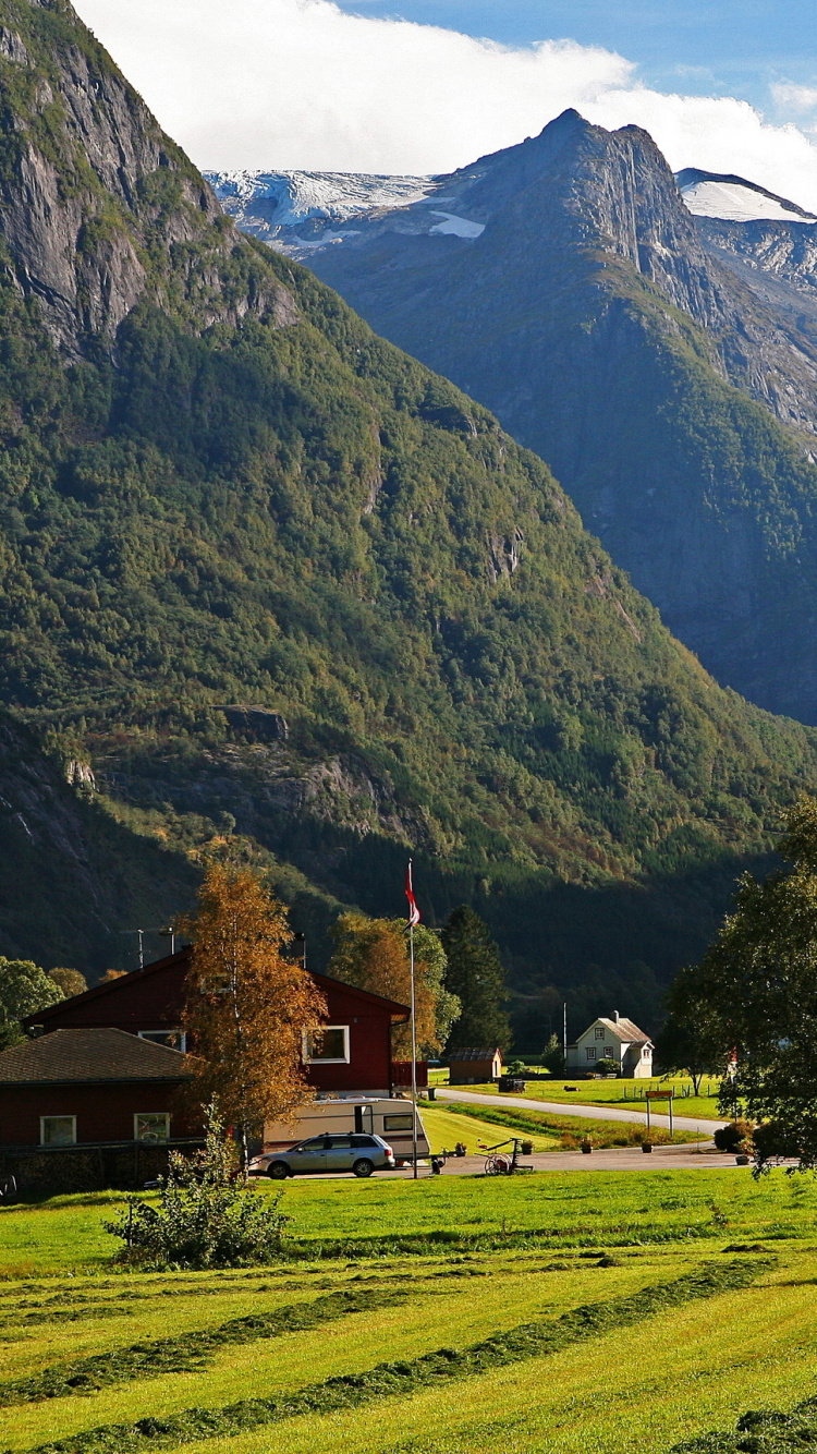 Brown House on Green Grass Field Near Mountain During Daytime. Wallpaper in 750x1334 Resolution