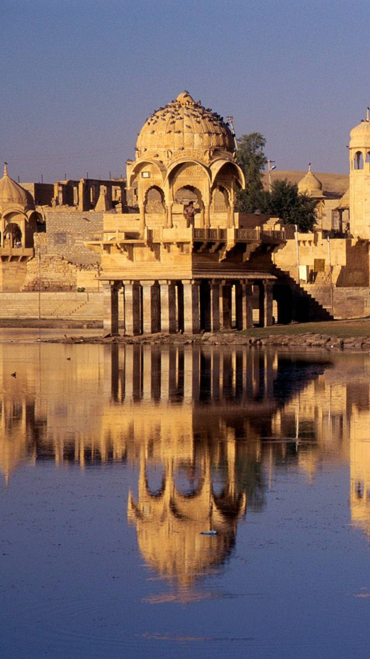 Bâtiment en Béton Brun Près D'un Plan D'eau Pendant la Journée. Wallpaper in 750x1334 Resolution