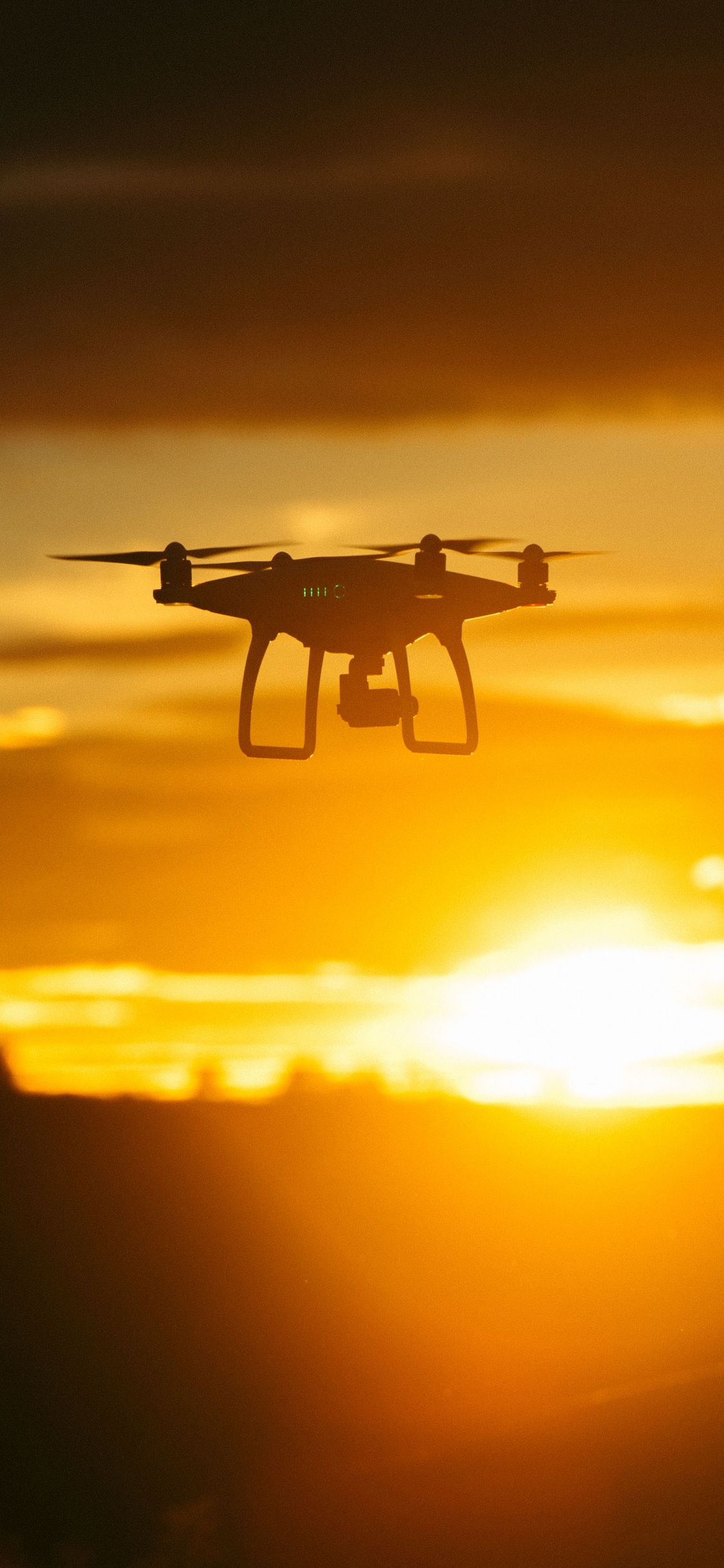 Drone Blanco Volando Durante la Puesta de Sol. Wallpaper in 1125x2436 Resolution