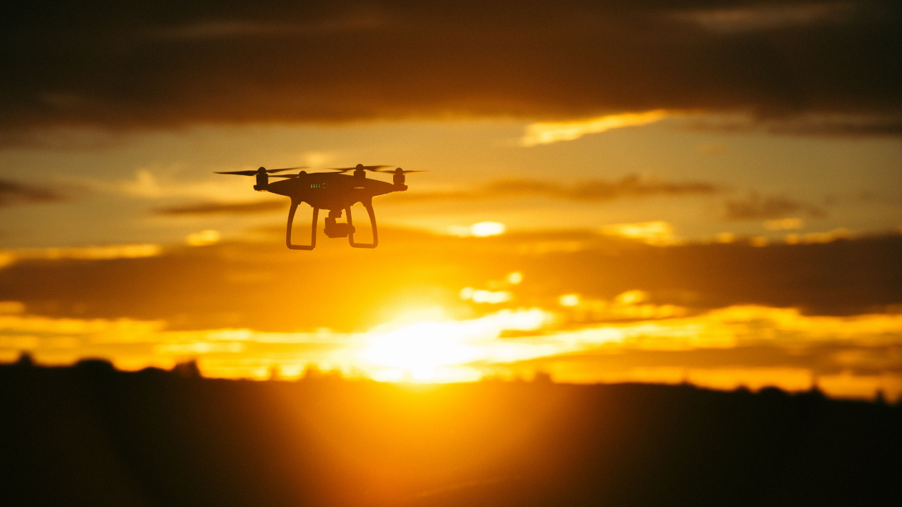 Weiße Drohne Fliegt Bei Sonnenuntergang. Wallpaper in 1280x720 Resolution