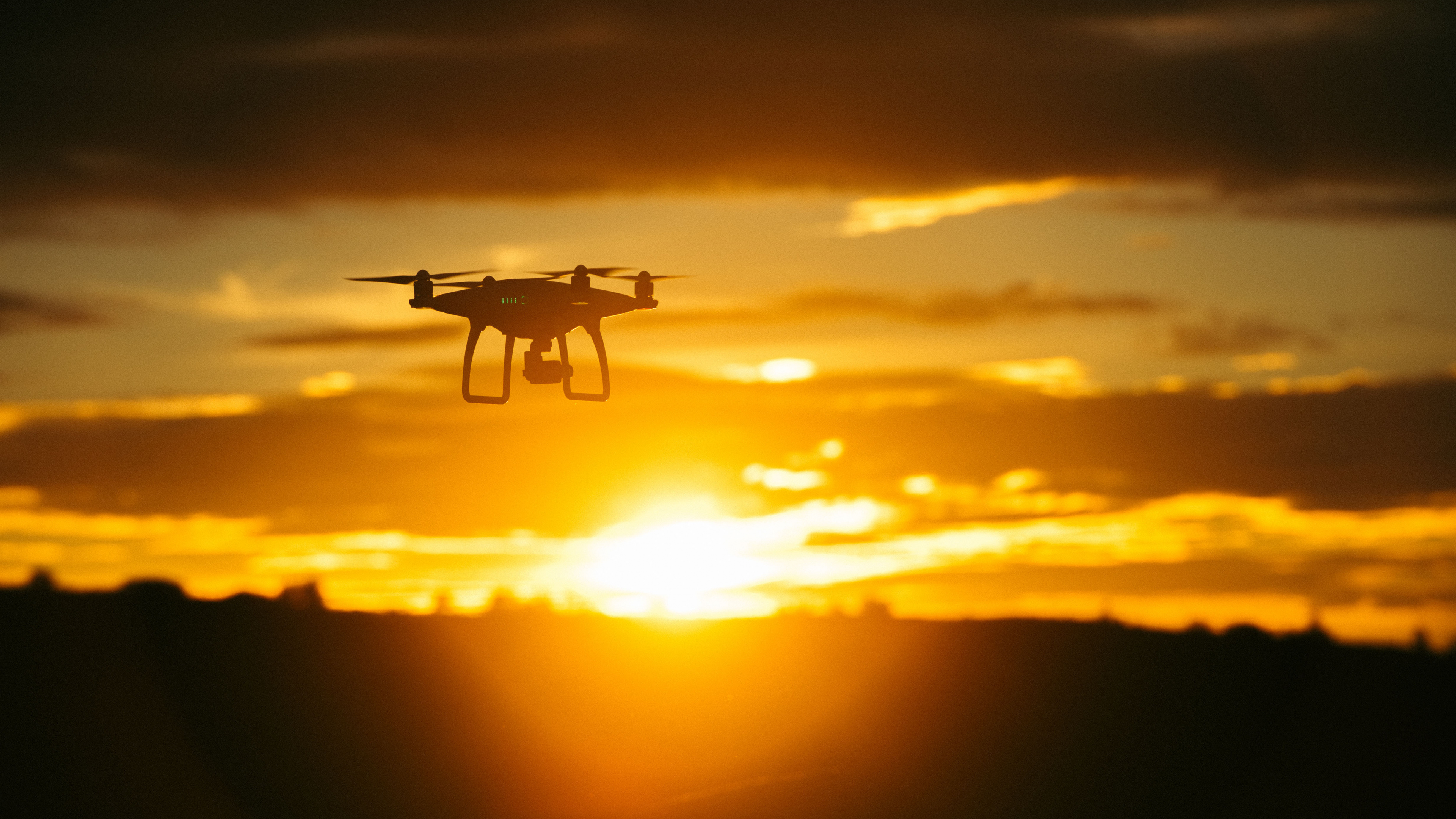 Weiße Drohne Fliegt Bei Sonnenuntergang. Wallpaper in 3840x2160 Resolution