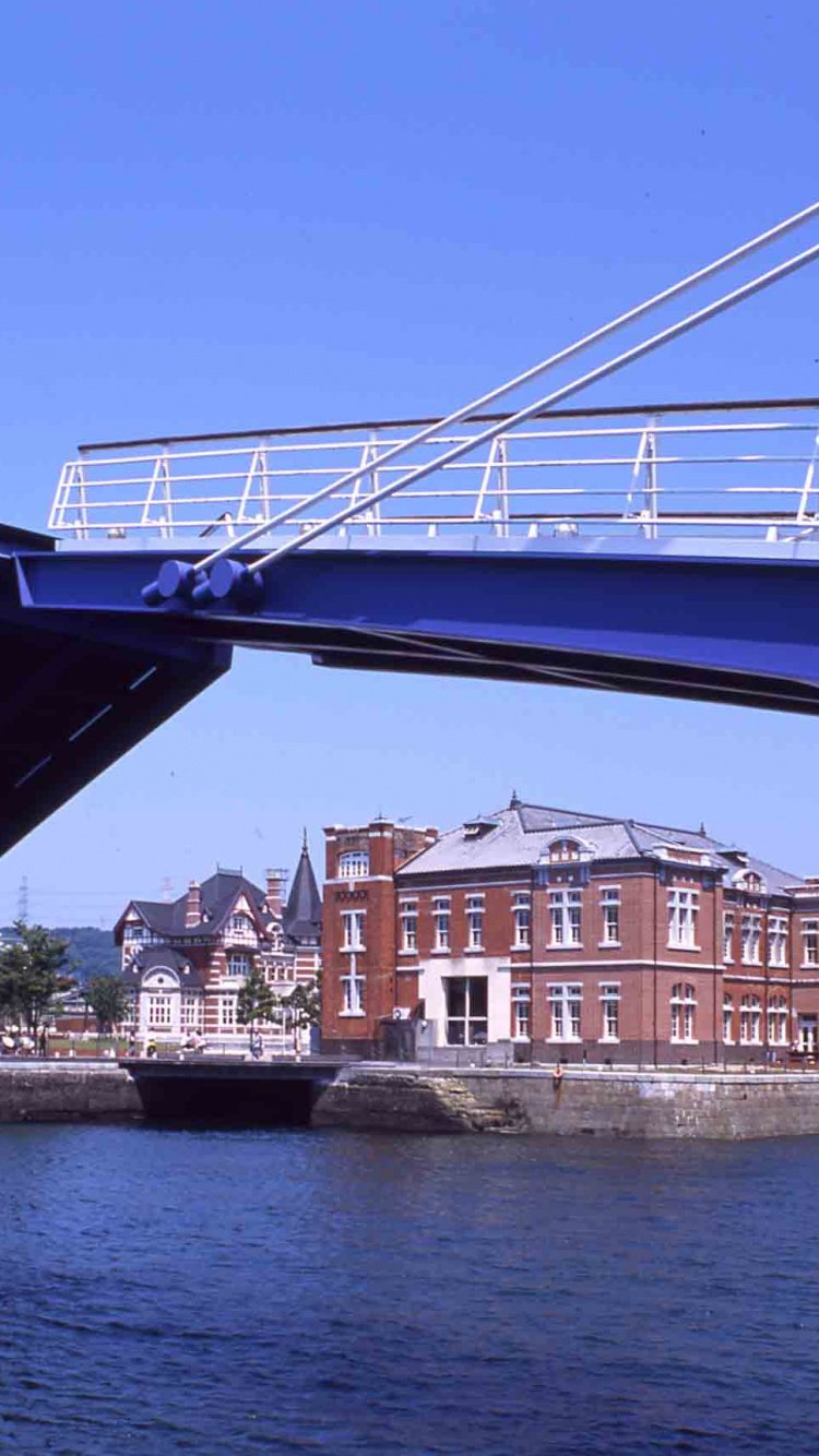 Weißes Und Braunes Betongebäude in Der Nähe Der Brücke Unter Blauem Himmel Tagsüber. Wallpaper in 750x1334 Resolution