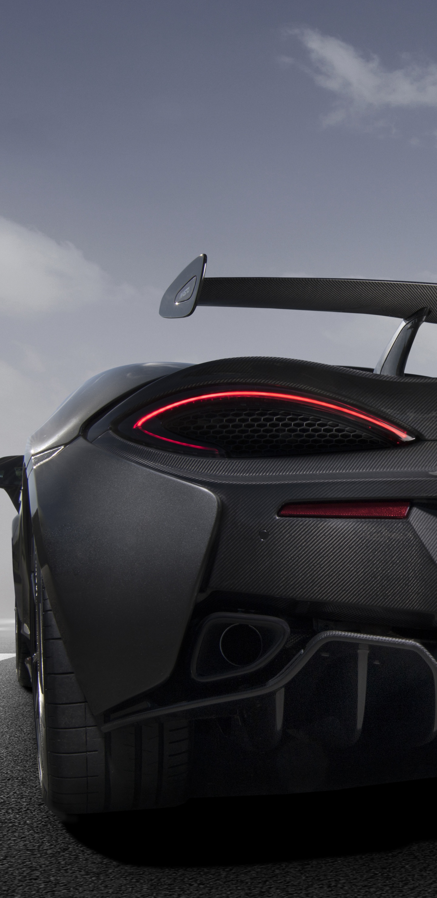 Schwarzer Porsche 911 Auf Grauer Asphaltstraße Unter Grauem Wolkenhimmel. Wallpaper in 1440x2960 Resolution