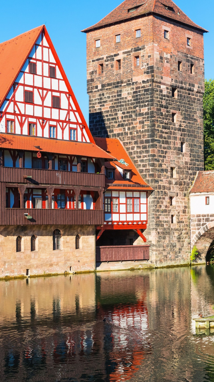 Braunes Backsteingebäude am Fluss Tagsüber. Wallpaper in 750x1334 Resolution