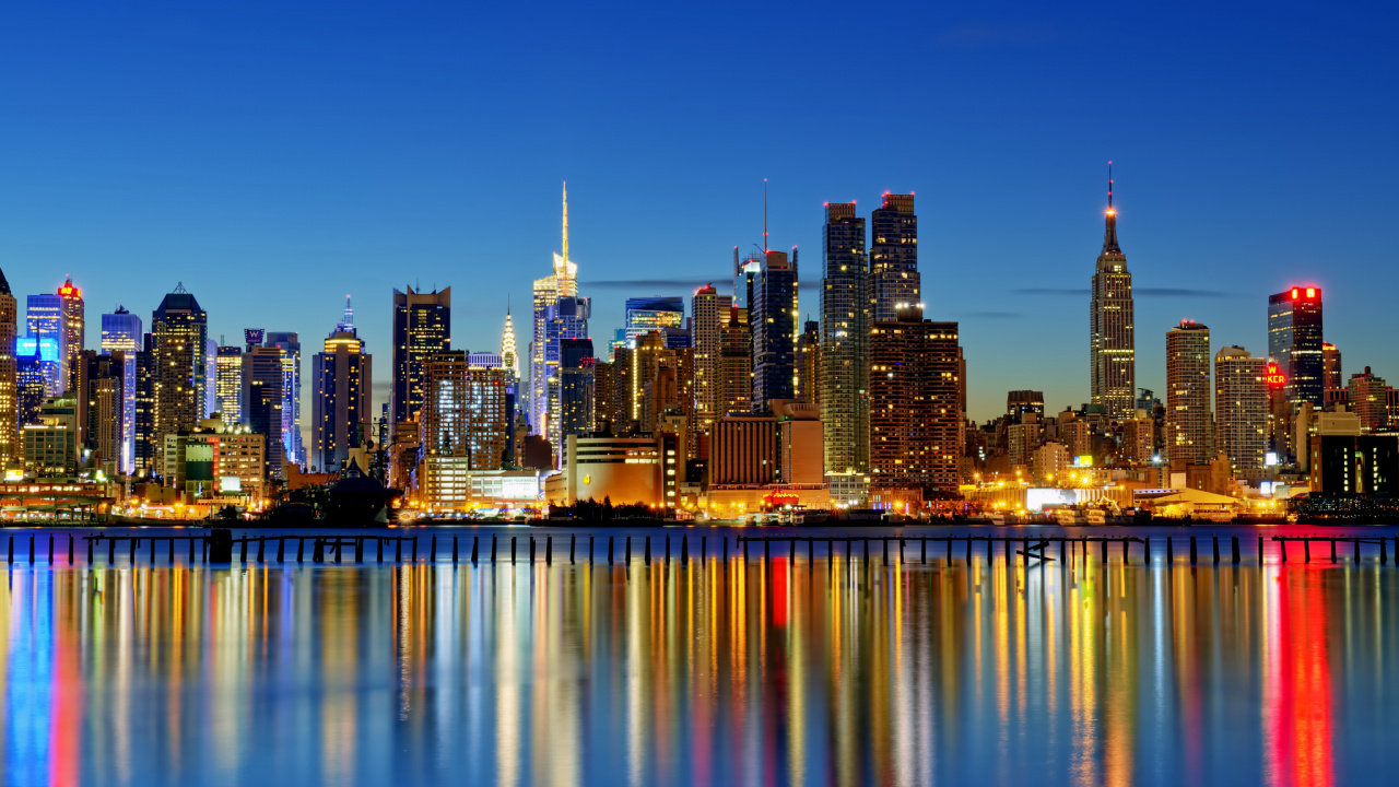 Skyline Der Stadt Über Gewässer Während Der Nacht. Wallpaper in 1280x720 Resolution