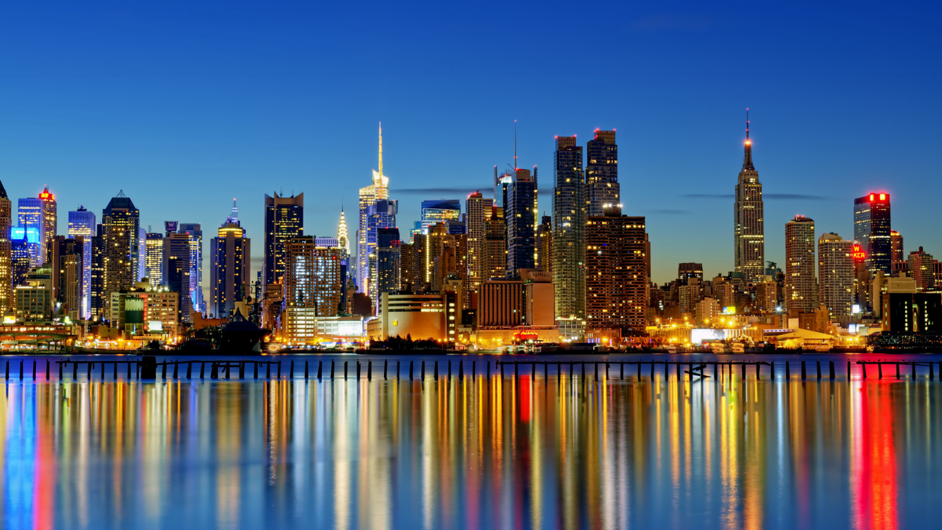 Skyline Der Stadt Über Gewässer Während Der Nacht. Wallpaper in 1366x768 Resolution