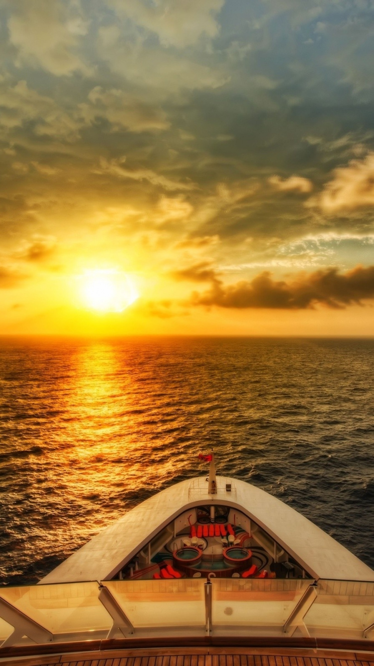 Weißes Boot Auf Dem Meer Bei Sonnenuntergang. Wallpaper in 750x1334 Resolution