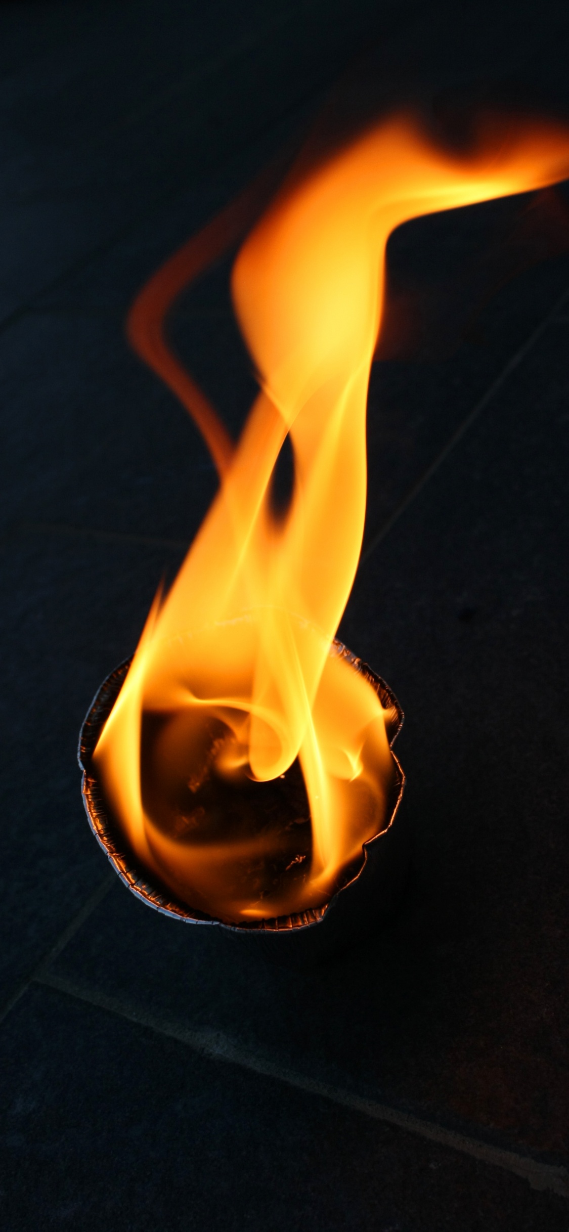 Fuego en Piso de Concreto Negro. Wallpaper in 1125x2436 Resolution