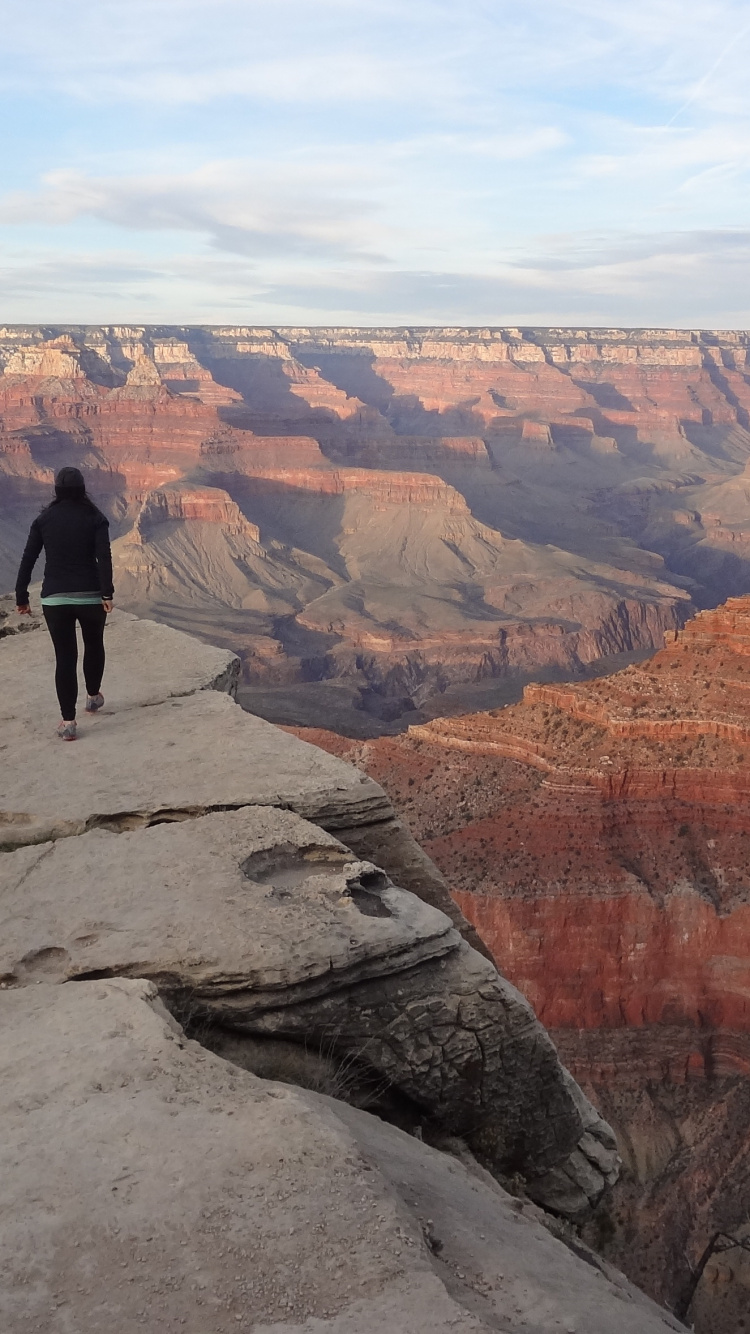 Mann in Schwarzer Jacke, Der Tagsüber Auf Einer Felsformation Steht. Wallpaper in 750x1334 Resolution