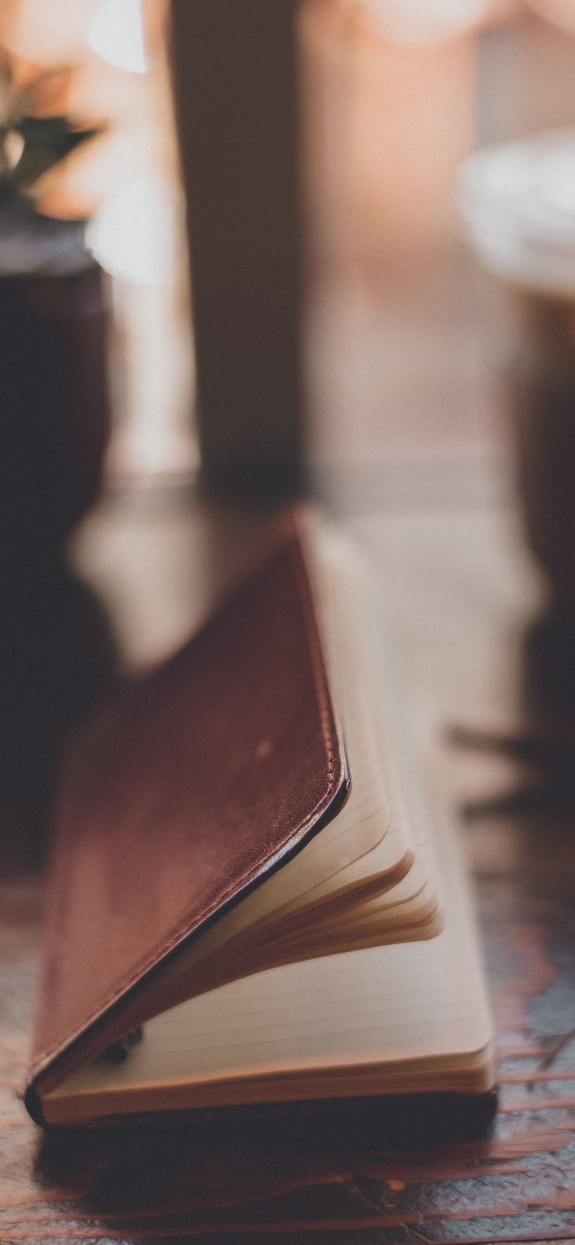 Brown Book on Brown Wooden Table. Wallpaper in 1125x2436 Resolution