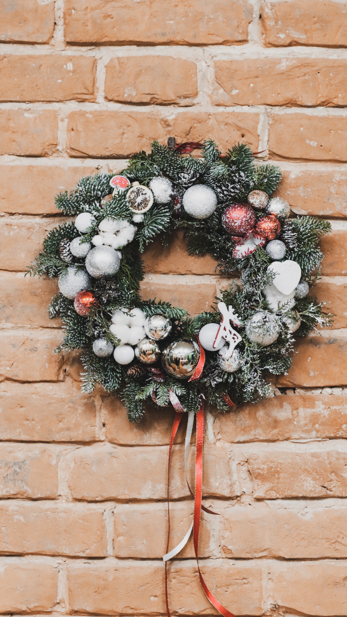 Green and White Wreath on Brown Brick Wall. Wallpaper in 1440x2560 Resolution