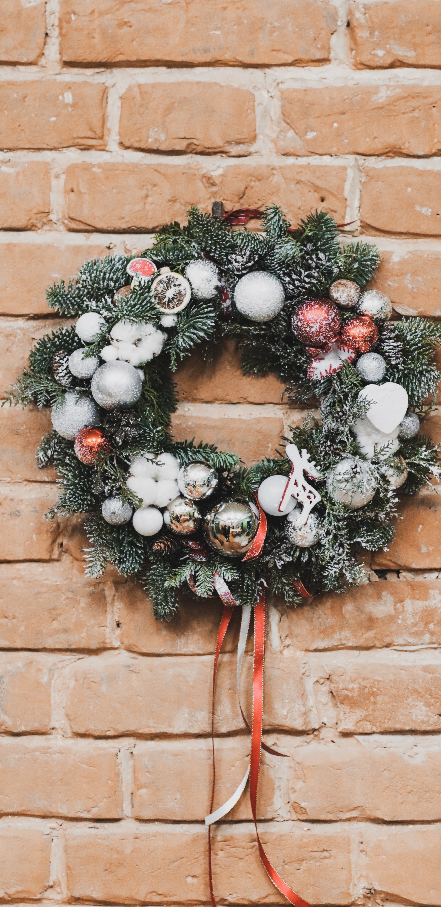 Grün-weißer Kranz Auf Brauner Backsteinmauer. Wallpaper in 1440x2960 Resolution