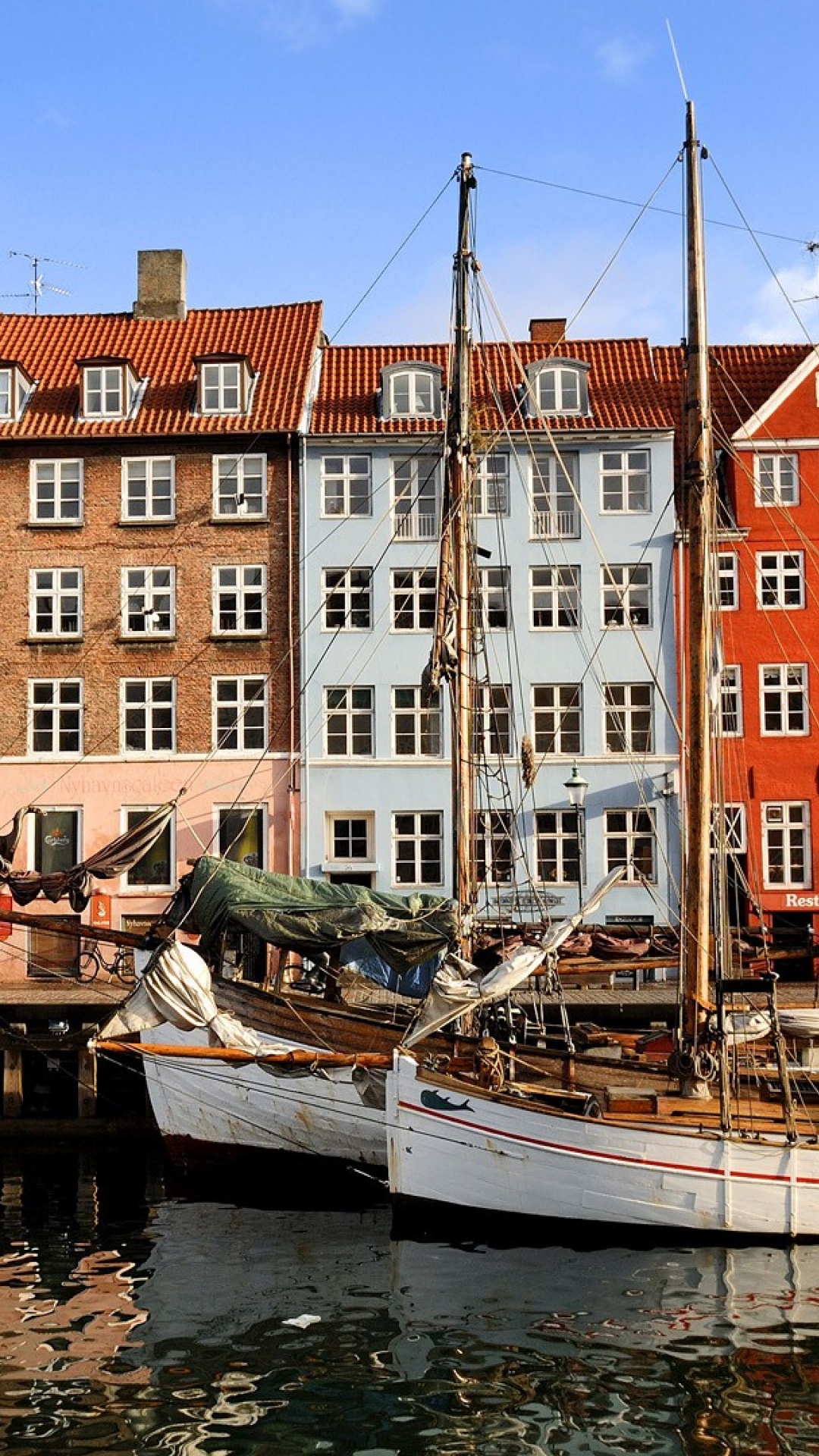 Weißes Und Braunes Boot Auf Dem Wasser in Der Nähe Des Braunen Betongebäudes Tagsüber. Wallpaper in 1080x1920 Resolution